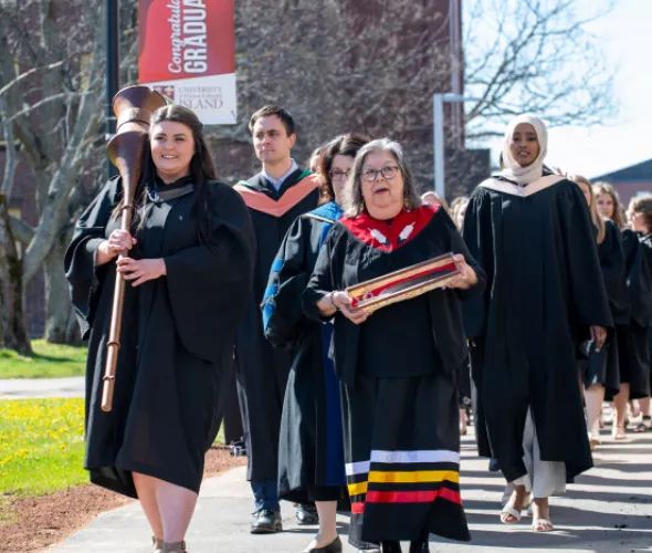Macebearer Katherine Guarino and Eagle Feather Bearer Dr. Judy Clark, Elder in Residence at UPEI, lead graduates in the faculties of Nursing and Veterinary Medicine into the Chi-Wan Young Sports Centre for their Convocation ceremony on May 14.