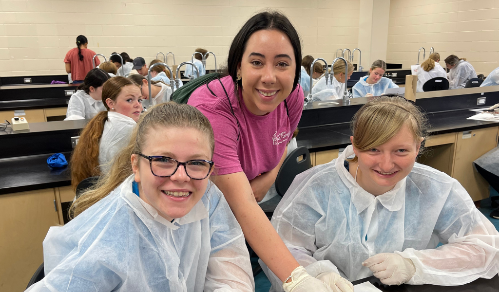 Camp Counsellor Kayla Dalpe and campers from 2023 perform a fish dissection