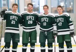 Four smiling male hockey players