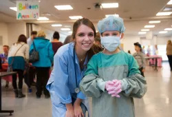 a youngster learns how to gown and glove like a veterinary surgeon