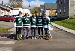 Five female hockey players stand at an intersection in Charlottetown