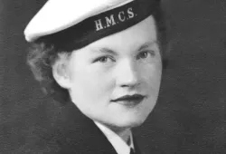 A black and white close-up photo of a woman from the World War II era with a sailor's cap which reads HMCS on the band