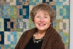 photo of woman with a quilt in background