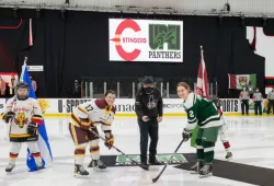 photo of man dropping the ceremonial puck at women's hockey game