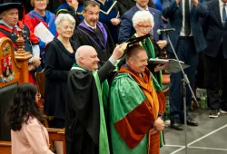 John Horrelt, who received an honorary degree from UPEI during Convocation 2023, receives his hat, part of his academic regalia, from Dr. Greg Keefe, interim president and vice-chancellor.