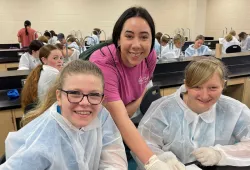 Camp Counsellor Kayla Dalpe and campers from 2023 perform a fish dissection