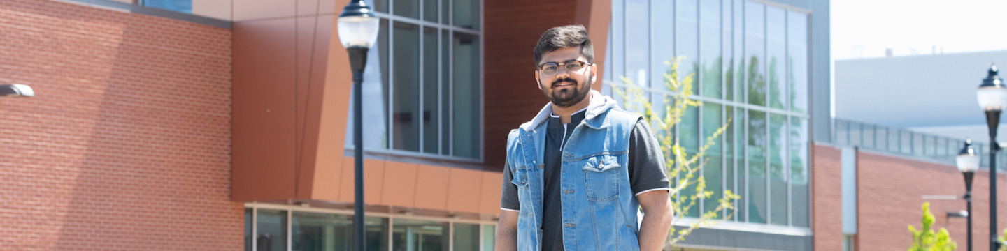 upei engineering graduate darvin patel in front of the sustainable design engineering building