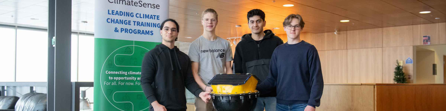 four students standing with a data buoy they created 