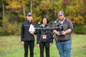 researchers look at a drone