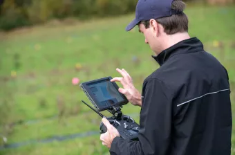 A drone pilot operates a remote control