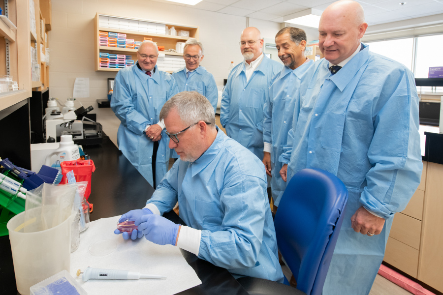 MPs Wayne Easter and Sean Casey watch a demonstration in a dairy research lab at AVC.