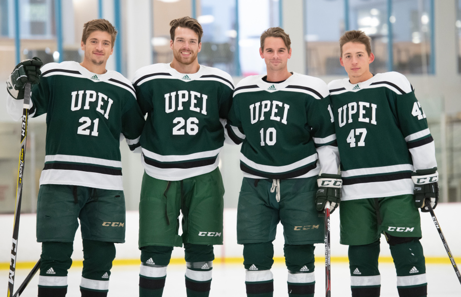 Four smiling male hockey players