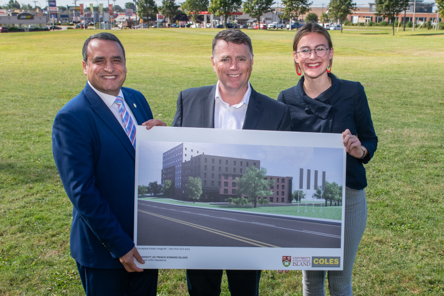 President Abd-El-Aziz, Premier King, and UPEI Student Union President Emma Drake hold a concept drawing on the site where UPEI's new residence will be built Photo of President, Premier, and Student Union President at site of new residence