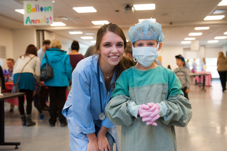 A youngster learns how to gown and glove like a veterinary surgeon. a youngster learns how to gown and glove like a veterinary surgeon