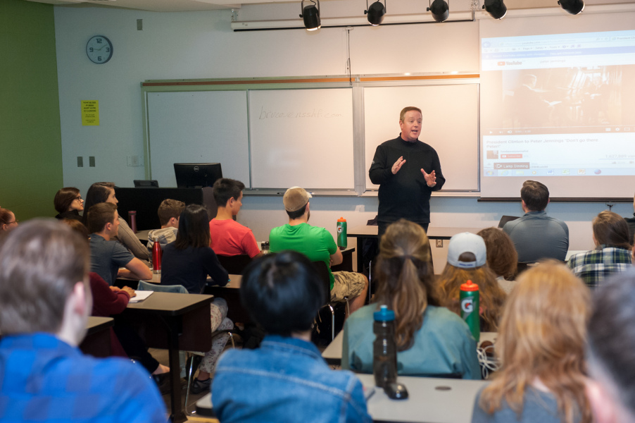 A man speaks in front of a classroom