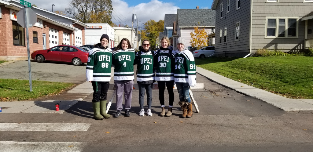Five female hockey players stand at an intersection in Charlottetown