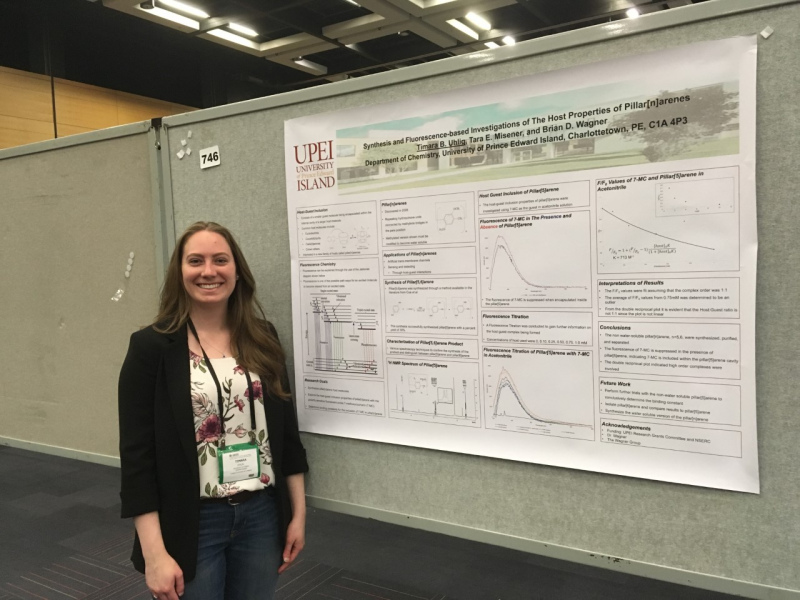 Timara Uhlig A female student standing in front of a large technical poster