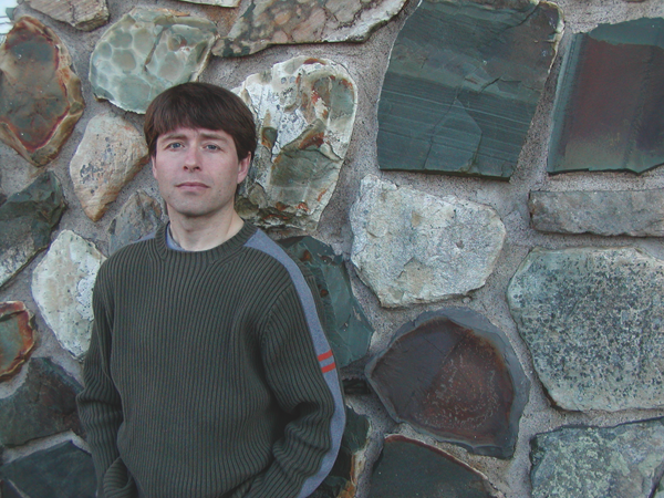 Michael Crummey A man stands against a stone wall