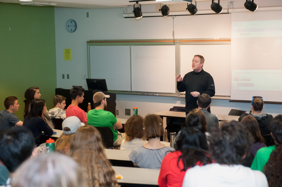 A man teaches at the front of a classroom