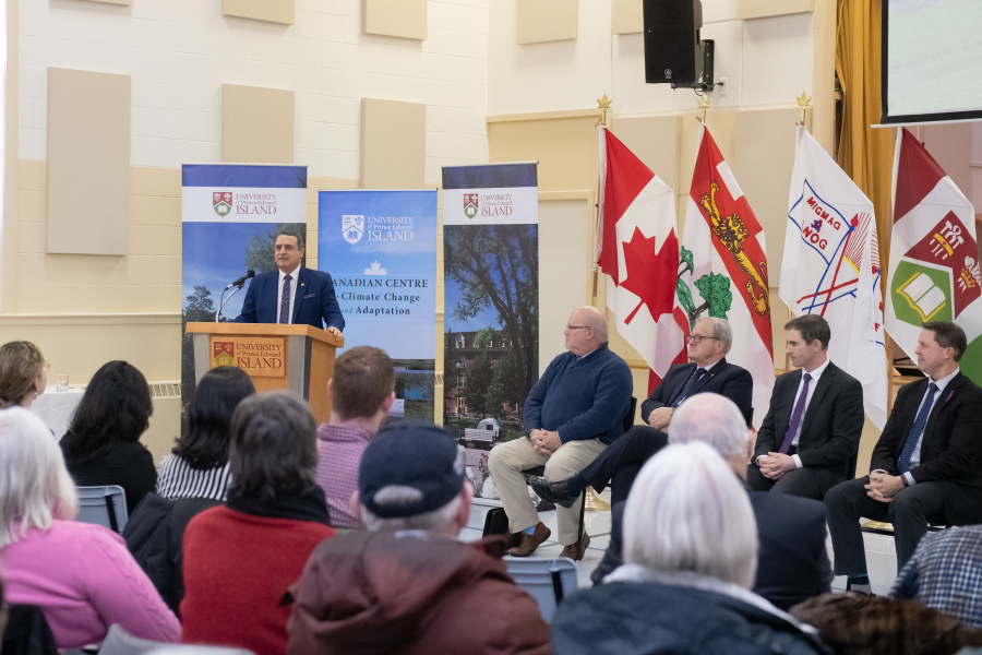 President Abd-El-Aziz addresses guests who gathered in St. Peter's Bay to learn more about UPEI's new climate change and adaptation centre, to be built nearby. Douglas Coles, Hon. Lawrence MacAulay, MLA Sidney MacEwen, and Hon. Brad Trivers are seated to his left. photo of the president speaking at St. Peter's Bay event