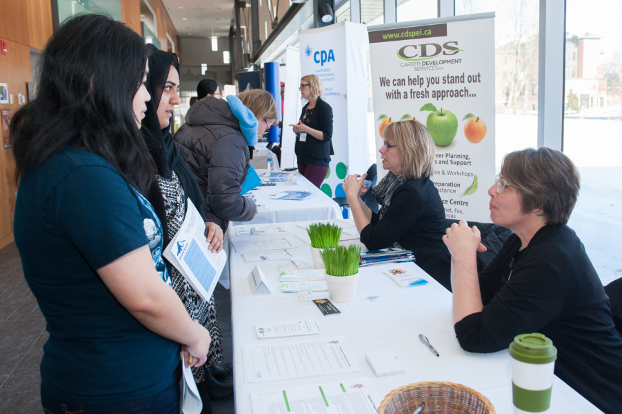 Two female students speak with a prospective employer