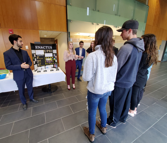 A male and female student speak with a group of students