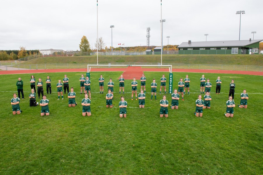The UPEI Women's Rugby team leads the pack with 18 Academic All-Canadians A group of female ruby players stand on a grass sports field