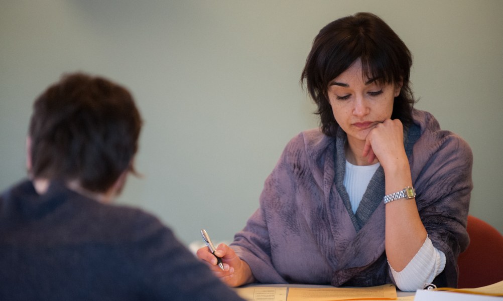 A woman studies intently at a desk