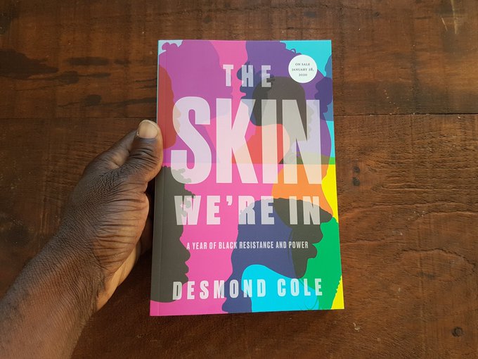 A photo of a copy of The Skin We're In held by a hand