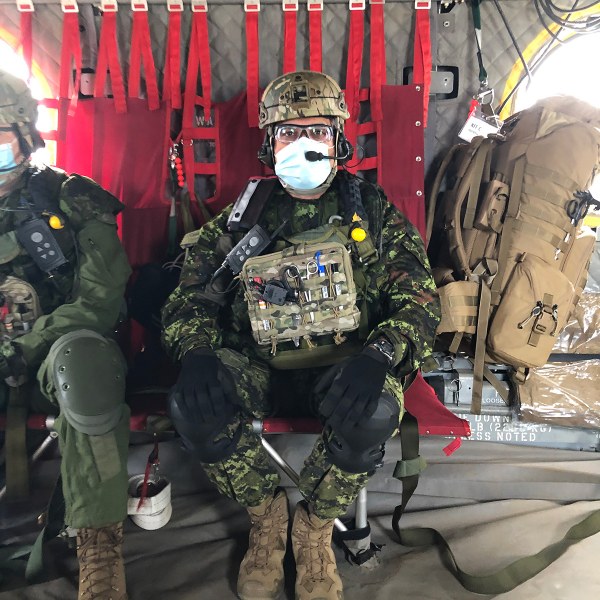 Dr. Trevor Jain A man in a military uniform strapped with medical gear and a helmet