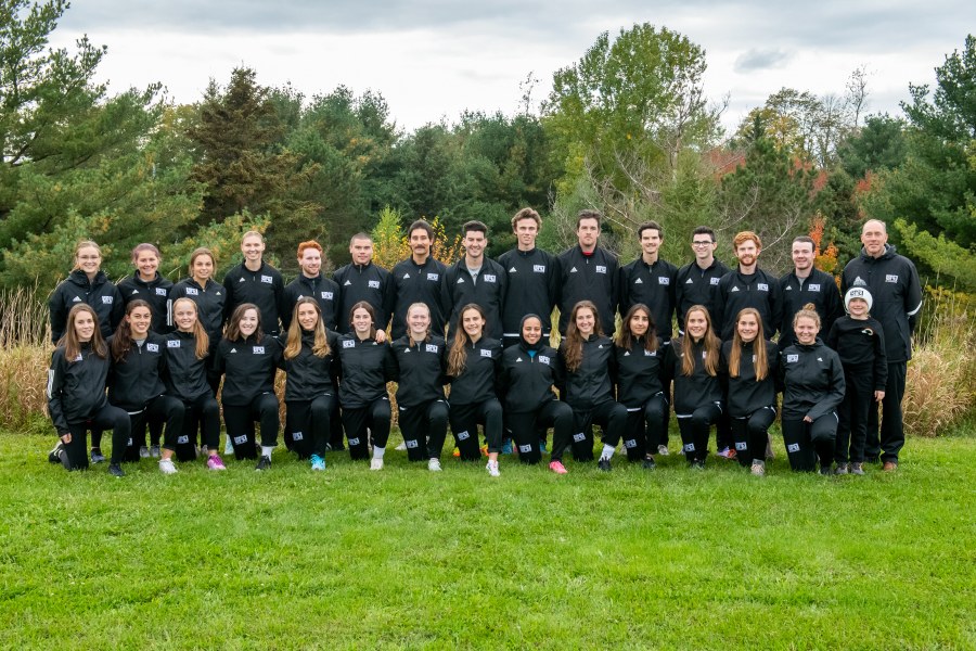 UPEI Cross Country A large group photo of two rows of runners, male and female, wearing black UPEI cross-country track suits