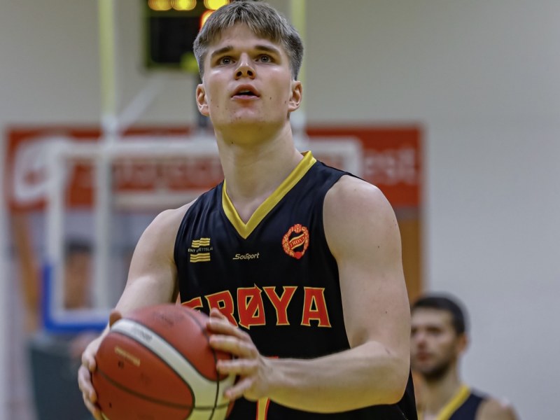 A male basketball player eyes the net looking to take a shot