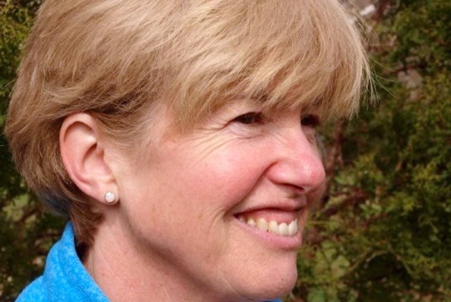 A closeup of a smiling woman with shorter hair
