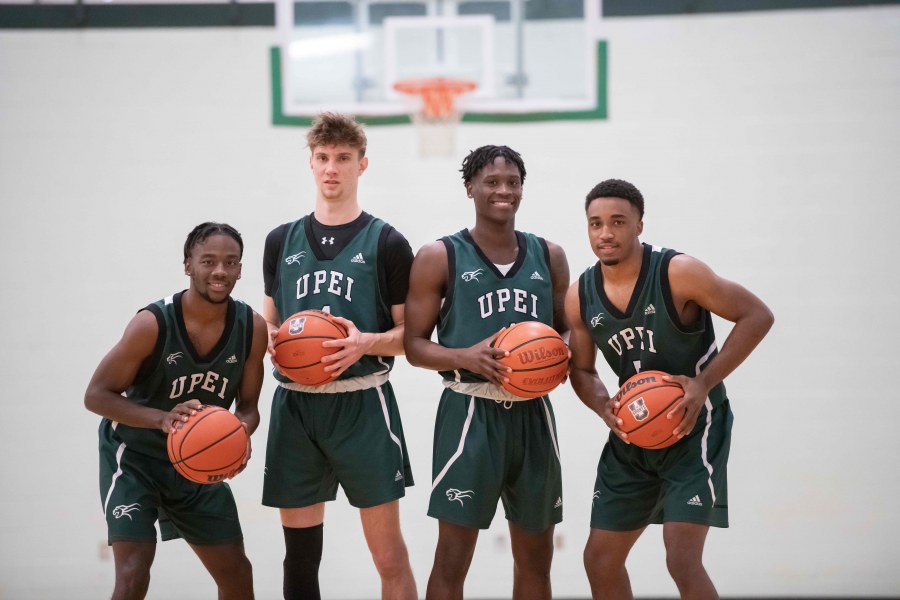 photo of four UPEI Men's Basketball players each holding a basketball