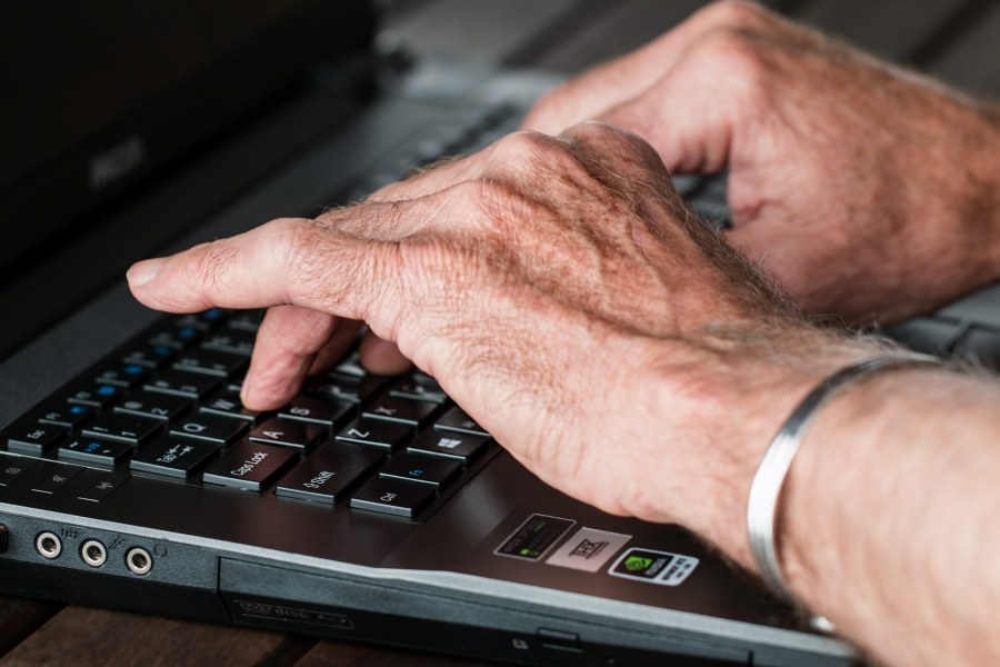 A senior types on a keyboard.