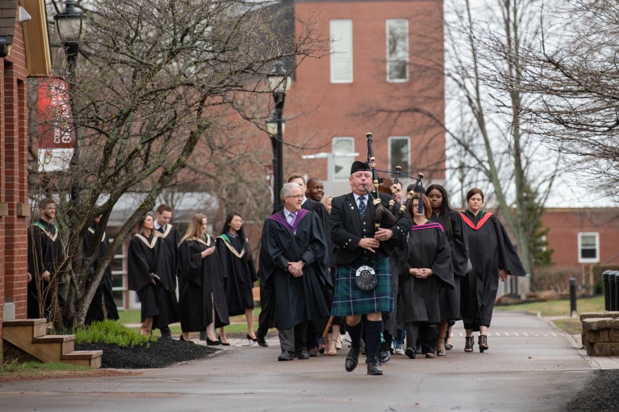 photo of convocation academic procession led by a bagpiper