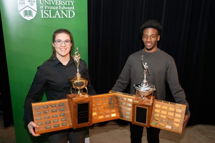 photo of woman and man holding trophies