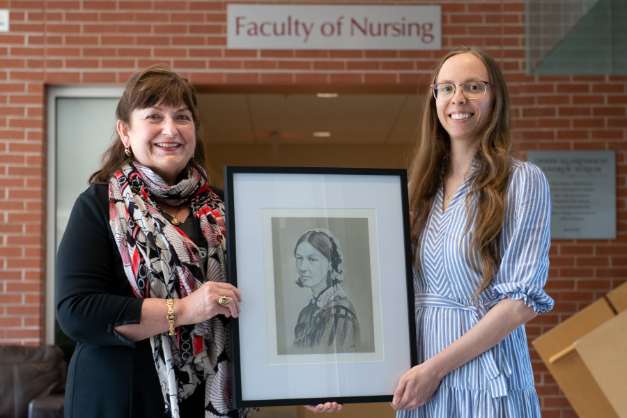 Katarina McCourt (right) presents Dr. Jo-Ann MacDonald, interim dean of nursing, with a portrait of Florence Nightingale that she created. Dr. Jo-Ann MacDonald and Katarina McCourt with McCourt's portrait of Florence Nightingale