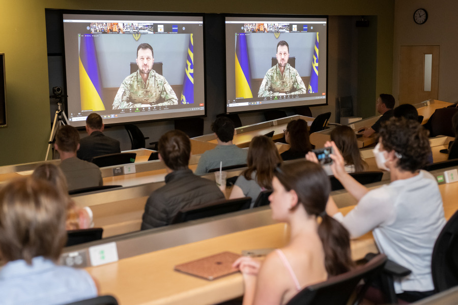 image of students in classroom watching two screens
