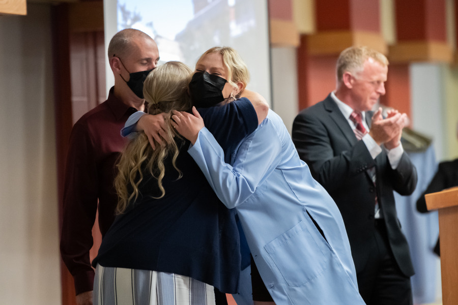 Emily Vickery, Class of 2026, receives her blue coat from her aunt and uncle. 