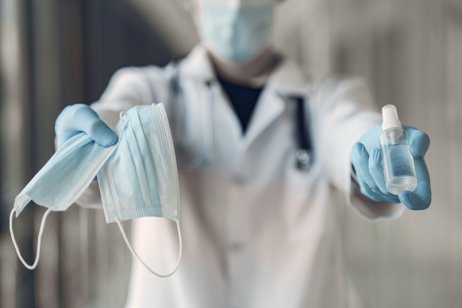 Photo of person holding masks and sanitizer