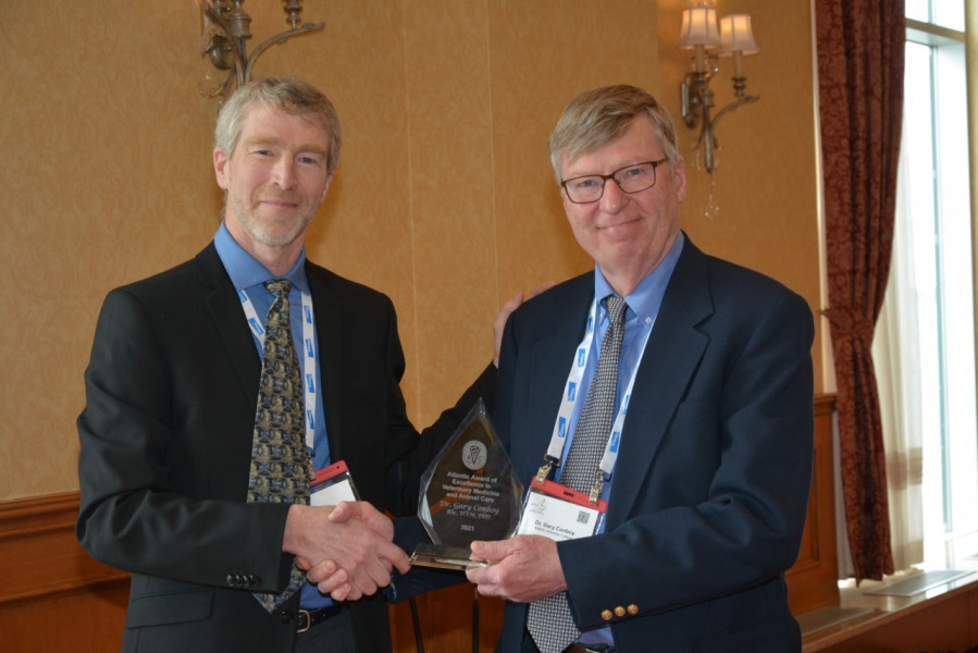 Dr. Gary Conboy receives the Atlantic Award of Excellence in Veterinary Medicine and Animal Care from Dr. John VanLeeuwen, interim dean, AVC, in 2022. 