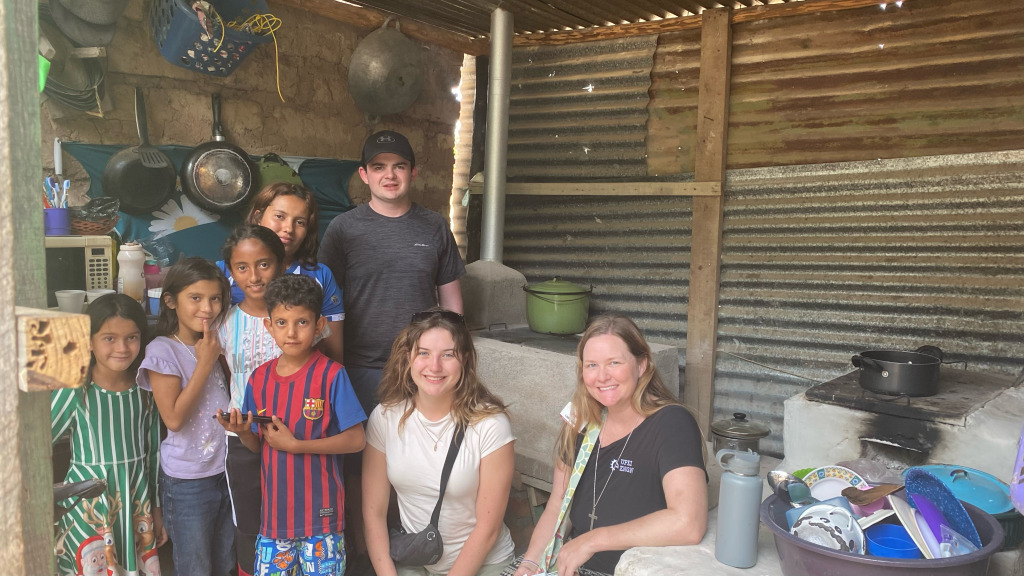 Dr. Libby Osgood (right) and UPEI engineering students Ben McQuaid (standing centre) and Lilly O'Reilly (seated centre), with one of the families that received an eco-stove