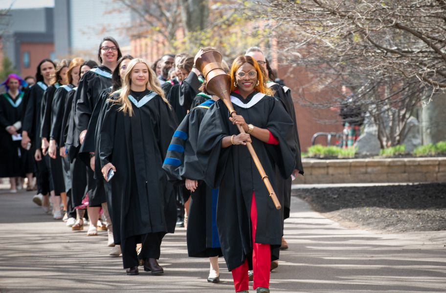 Macebearer Gloria Chimwe-Etu Wonodi leads graduates in the faculties of Arts, Education, and Graduate Studies into the Chi-Wan Young Sports Centre for their convocation ceremony on May 18.