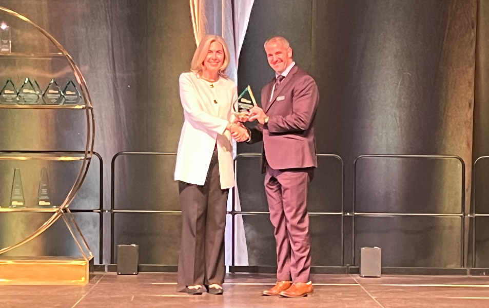 UPEI Faculty of Medicine COO Paul Young received his Top 50 CEO award in Halifax on May 11. Woman handing a trophy to a man, standing on a stage