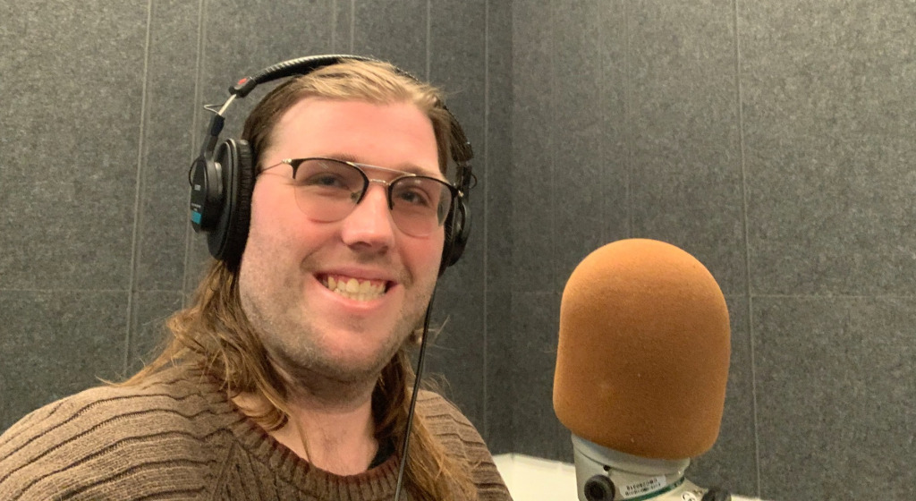 Daniel Cousins, a third-year UPEI student is looking for "ideas worth spreading" for a TEDx Charlottetown talk. Image of person with headphones on in front of a mic