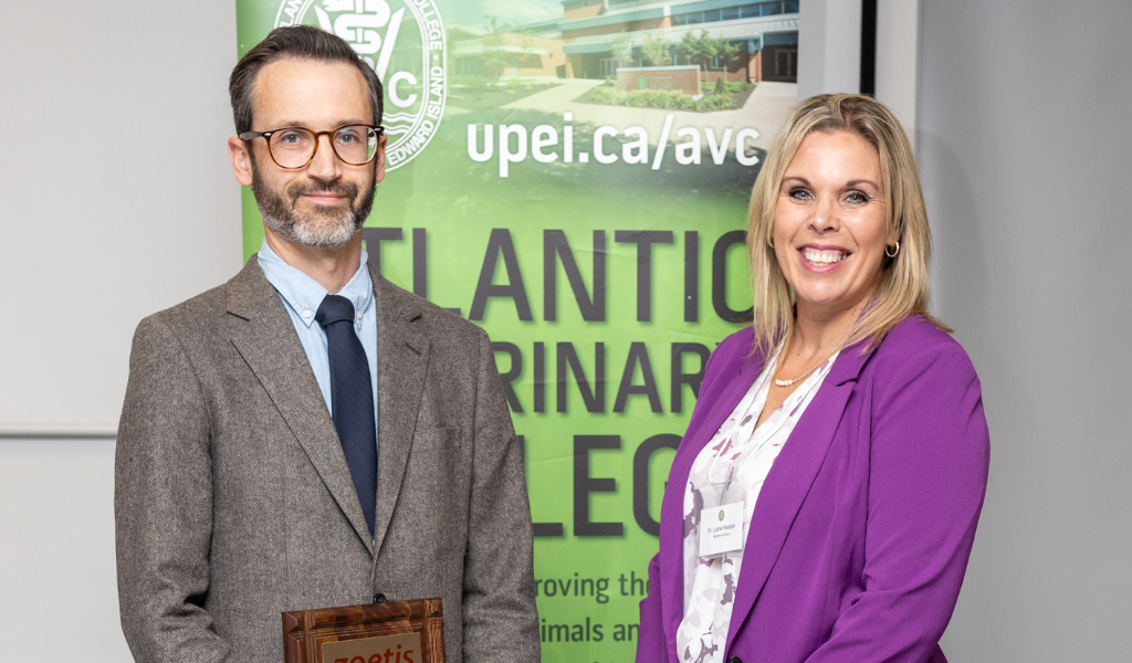 Dr. Russell Fraser receives his Distinguished Teacher award from Dr. Liane Nelson of Zoetis Dr. Russell Fraser receives award