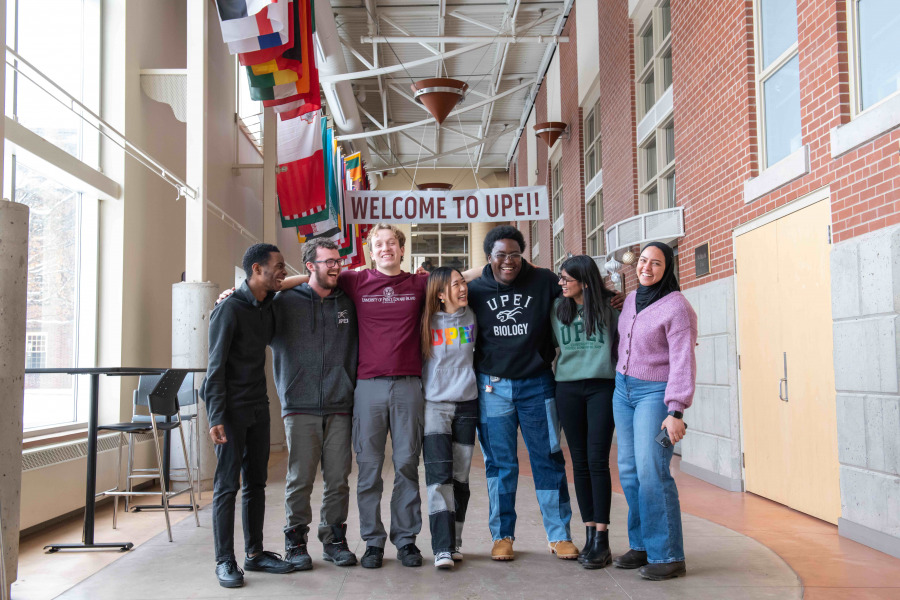 photo of 7 students standing together in large concourse