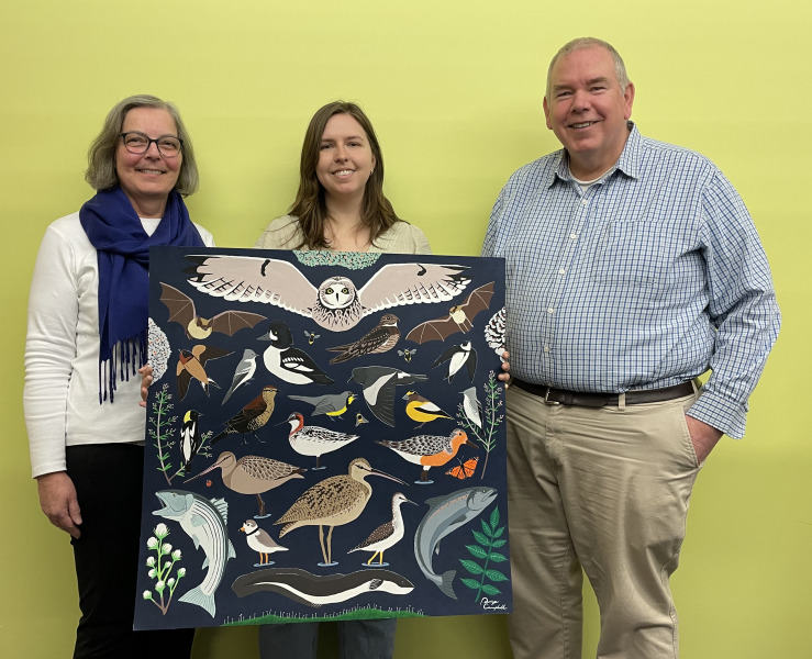 Three people display painting.