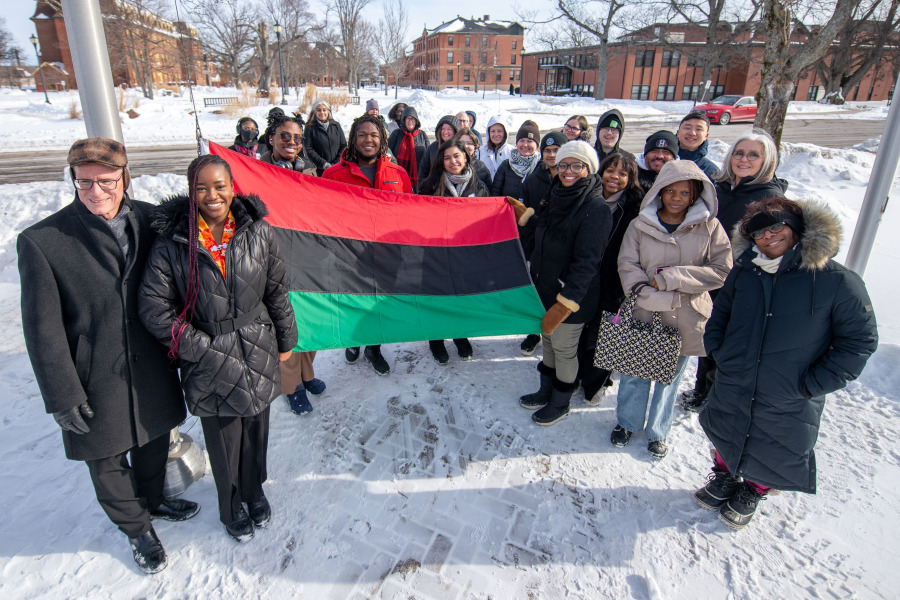 Displaying the Pan-African flag just before it was raised at UPEI to mark Black History Month are Dr. Greg Naterer (left), vice-president academic and research at UPEI; Jessica Ekeleme (second left), president of the African Students Association; and Tamara Steele (right), executive director of the Black Cultural Society of Prince Edward Island. Looking on are members of the UPEI and broader communities, including Dr. Wendy Rodgers, president and vice-chancellor of UPEI (far right). Pan-African flag raising at UPEI